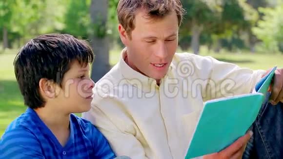 微笑的人和他的儿子一起读书视频的预览图