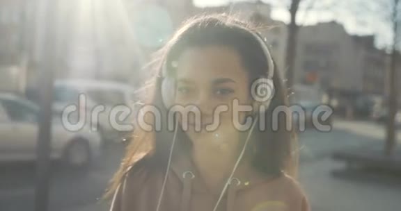 带着耳机的年轻女人在城市里享受时光视频的预览图