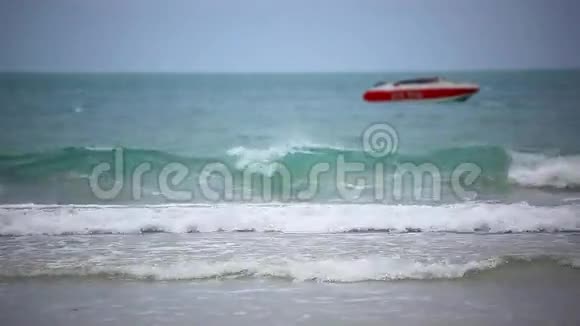 海滩上的红船多云期间的海浪视频的预览图