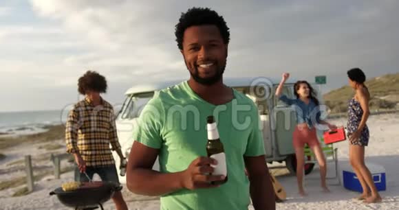 站在海滩上的人拿着啤酒瓶视频的预览图