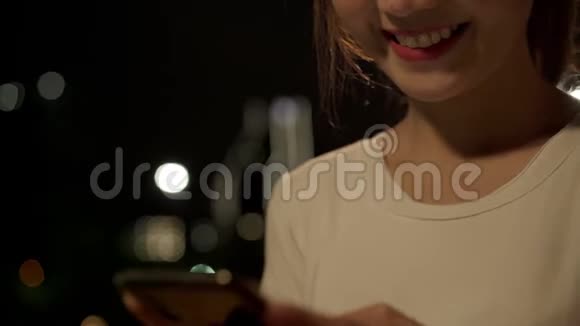 性格开朗的亚洲旅游博客女性在市中心大街上散步时在智能手机上使用触摸屏技术视频的预览图