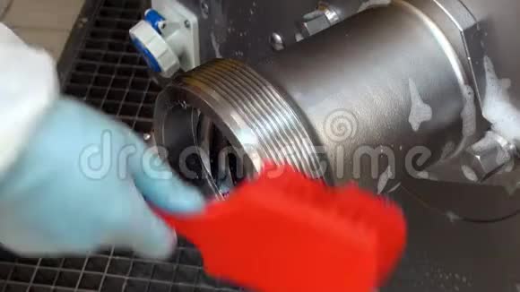 用红色泡沫刷手套清洗钢工业绞肉机视频的预览图