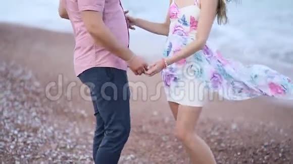 在黑山海滩上的情侣新婚夫妇正在散步视频的预览图