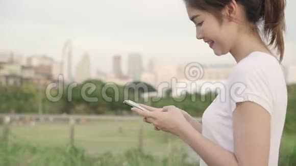亚洲旅游博客女性在街上行走时在智能手机上使用触摸屏技术视频的预览图