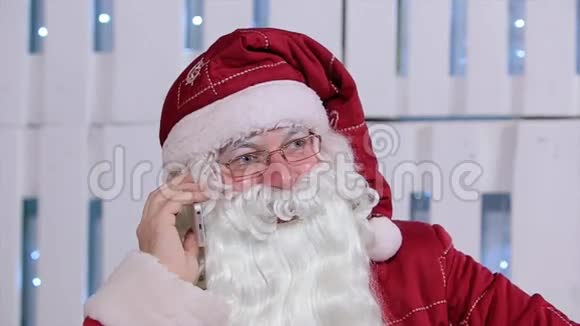 圣诞老人在房间里和他的电话交谈视频的预览图