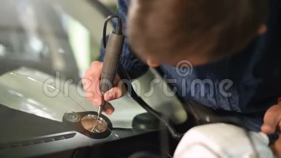 在车间从事消除汽车挡风玻璃裂缝的专业人员的特写聚合物视频的预览图