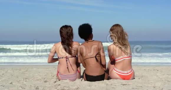 年轻女性朋友一起坐在沙滩上视频的预览图