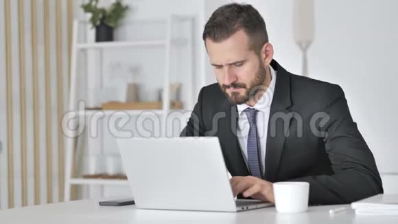 损失沮丧的商人在笔记本电脑上工作视频的预览图