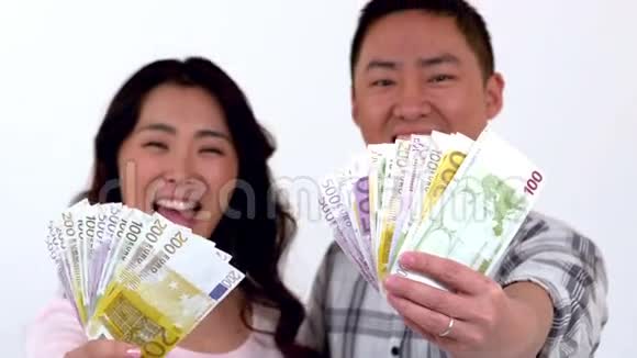 快乐的亚洲夫妇展示他的钱视频的预览图
