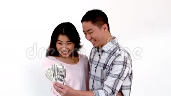 快乐的亚洲夫妇展示他的钱视频的预览图