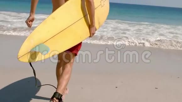 英俊的男人拿着冲浪板在水里奔跑视频的预览图