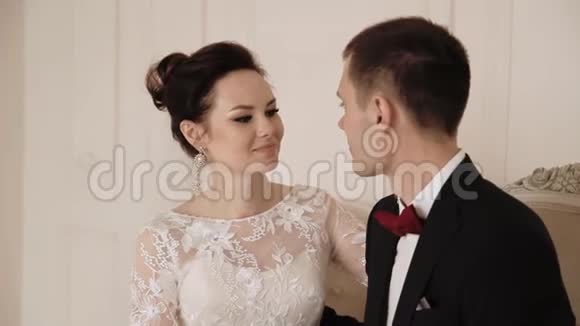 新婚夫妇在公寓里美丽的新娘和新郎在富裕的室内视频的预览图
