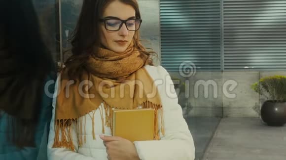 戴眼镜手拿书的年轻有魅力学生视频的预览图
