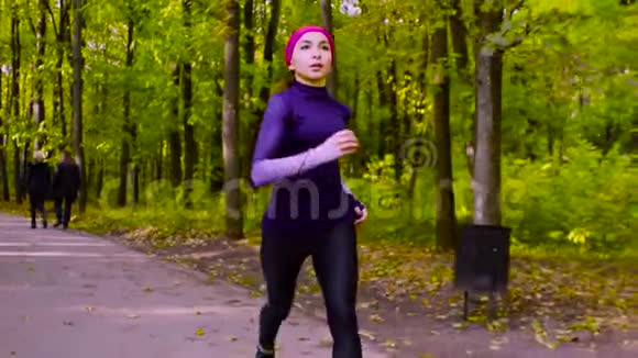 年轻的女人在公园里跑步健身视频的预览图