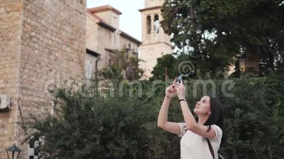 勇女用智能手机拍照时尚的夏日旅行女性与电话户外在欧洲城市老城区视频的预览图