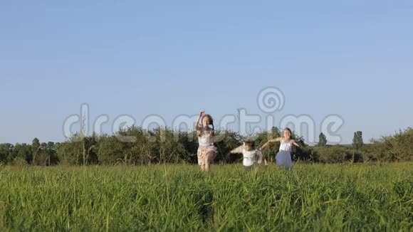 三个快乐的孩子在白天在田里玩耍视频的预览图
