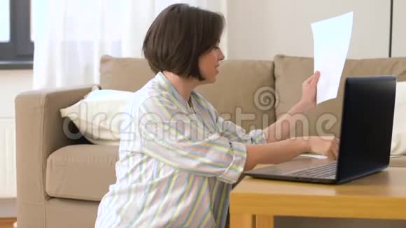 家里有笔记本电脑和文件的女人视频的预览图