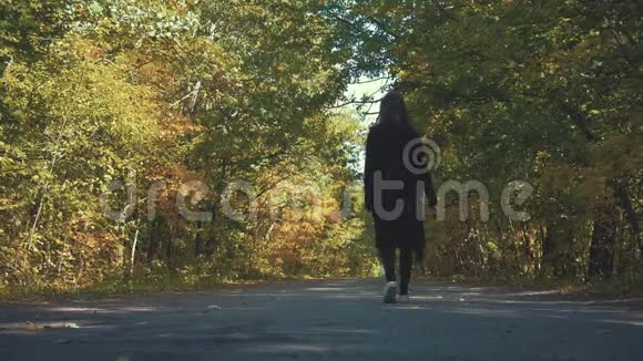 美丽的女孩走在秋天的公园里视频的预览图