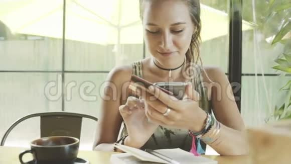 女人用信用卡在咖啡馆里用智能手机在线购物视频的预览图