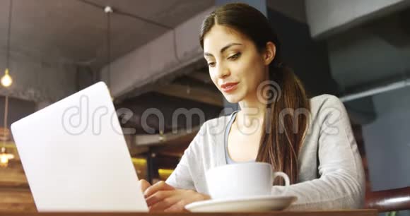 女人在咖啡馆里用笔记本电脑视频的预览图