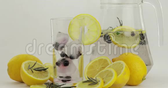 倒一杯冷饮喝杯里的柠檬和冰新鲜鸡尾酒视频的预览图