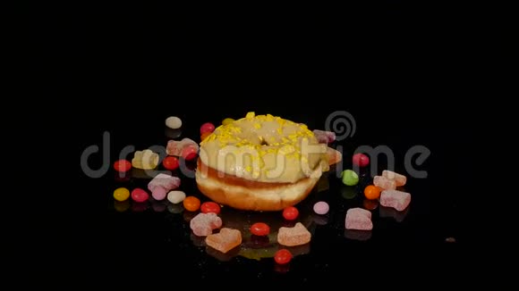 黄色有趣的惊喜釉面甜甜圈与洒条纹焦糖糖果五颜六色的葡萄干或花生粥视频的预览图