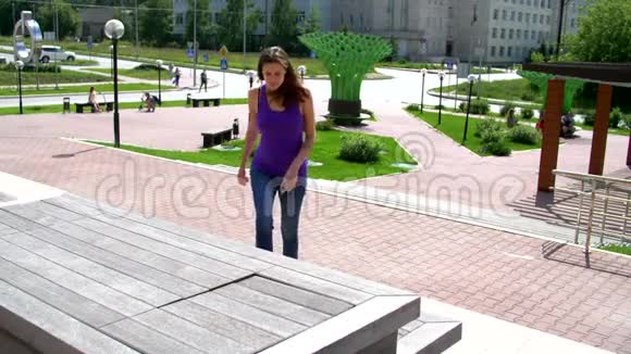 女孩坐在长凳上视频的预览图