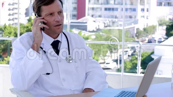 在电话和笔记本电脑上工作的医生视频的预览图