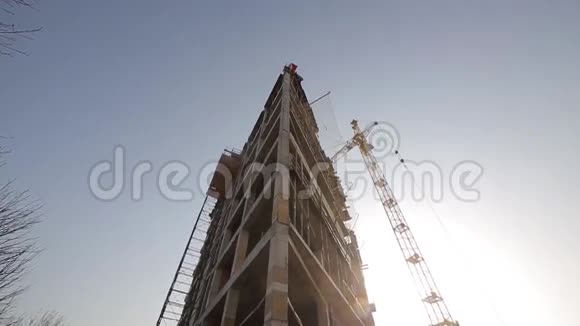 在背景塔式起重机中建造一座混凝土建筑视频的预览图