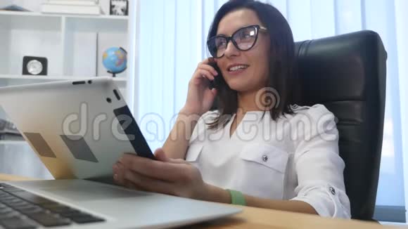 一位成功的美女在现代办公室打电话视频的预览图