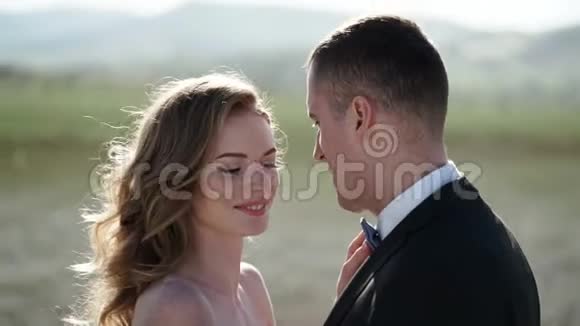 年轻漂亮的新娘穿着婚纱新郎拥抱亲吻视频的预览图