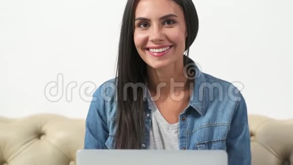 坐在沙发上的年轻女人视频的预览图