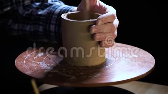 在陶工的车轮上用手捏紧粘土陶工用陶制工具在陶工身上塑造粘土制品视频的预览图
