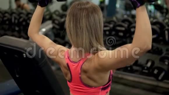 年轻的健身女子在健身房锻炼视频的预览图