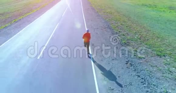 完美柏油路上运动男子前方低空飞行视频的预览图