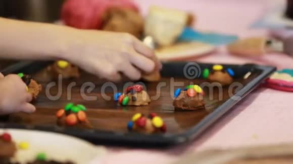 一个蹒跚学步的小男孩和他怀孕的母亲亲密地做巧克力饼干视频的预览图