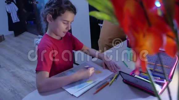 小女孩在桌子上画画女学生少年用铅笔在室内画画视频的预览图
