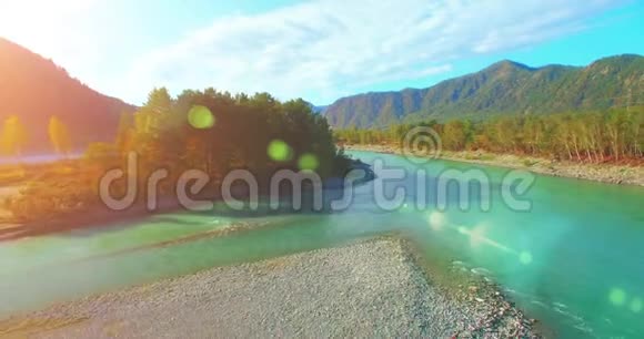 4kUHD鸟瞰图在阳光明媚的夏天早晨低飞过新鲜寒冷的山河绿树和太阳光视频的预览图