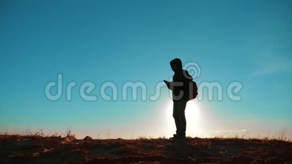 男人值得旅游与背包智能手机导航阳光站在生活方式山的顶部慢慢慢慢视频的预览图