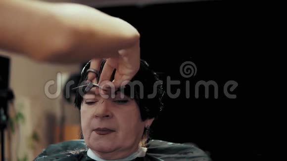 发型师在美发沙龙理发时剪女发视频的预览图