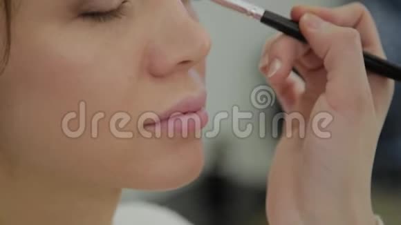 专业的化妆师使化妆成为一个非常漂亮的女人视频的预览图