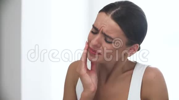 牙酸不快乐的女人带着强烈的牙齿疼痛的肖像视频的预览图