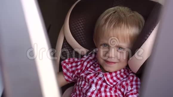 一个快乐男孩坐在车里的肖像视频的预览图