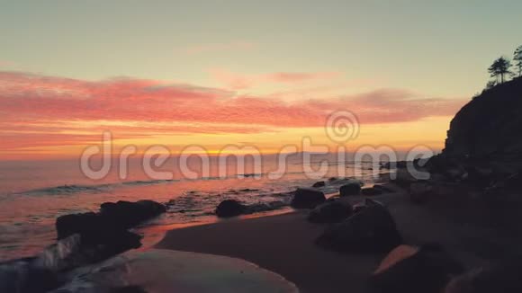 海浪和美丽的热带日出覆盖海岸线视频的预览图