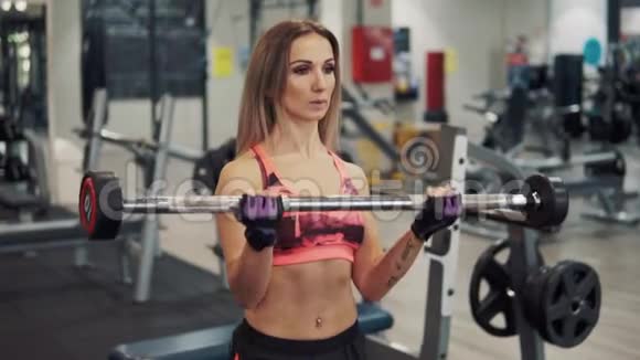 年轻的健身女子在健身房锻炼视频的预览图