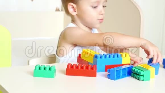 快乐的孩子在桌子上用彩色积木玩耍视频的预览图