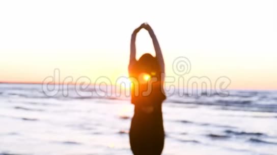 日落背景下的女人海岸上的太阳锻炼身体视频的预览图