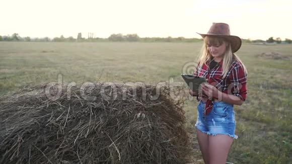 智慧农业慢动作视频概念女孩农学家在干草堆里拿着平板电脑正在学习视频的预览图
