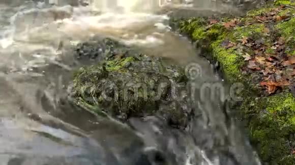 小山涧上的梯级水在玄武岩巨石上的大裂缝中流动气泡在水平乳白色的水上产生视频的预览图