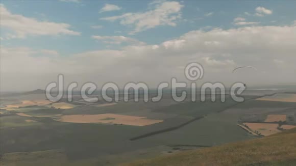 运动员滑翔伞飞行在他的滑翔伞旁边的燕子无人驾驶飞机的后续射击视频的预览图
